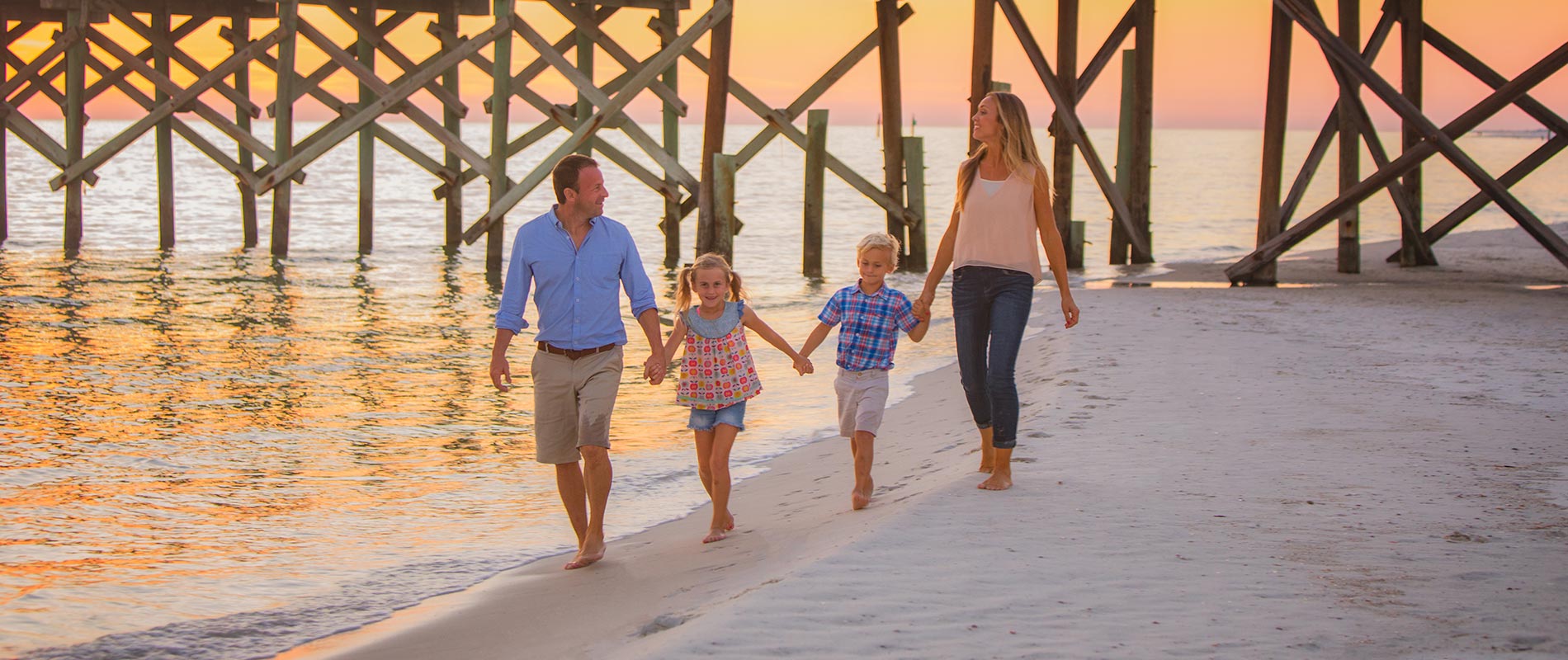family walking along gulf of mexico shoreline during sunset in mexico beach florida located in northwest florida