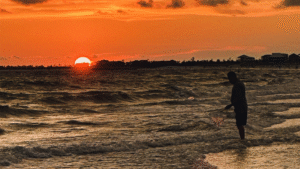 A man fishing at sunrise in Mexico Beach.