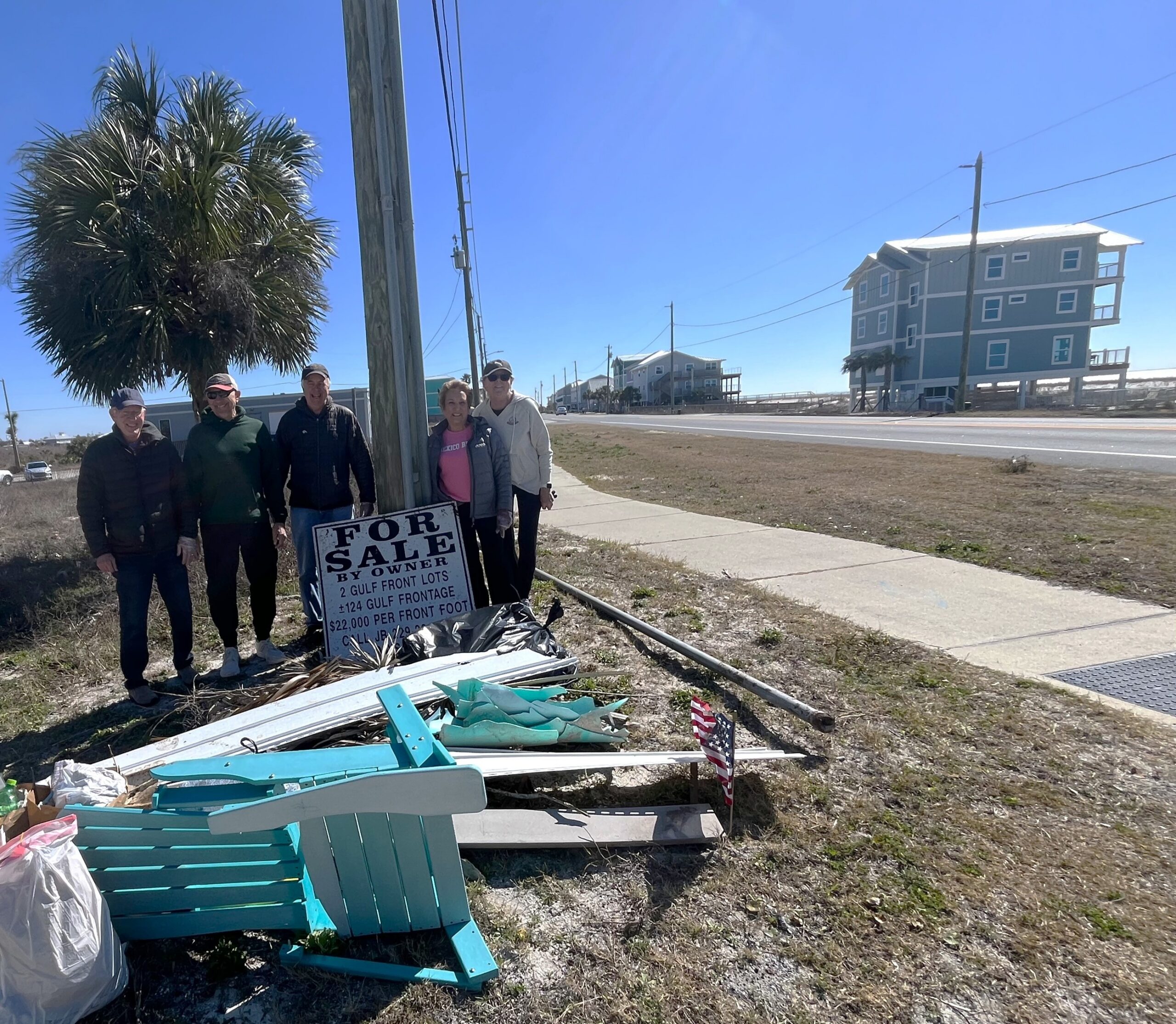 A group of people standing behind a pile of trash that has been cleaned up
